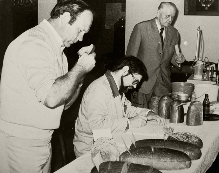 Ein historisches Foto zeigt Mitarbeiter von Leifert, welche das Brot überprüfen.