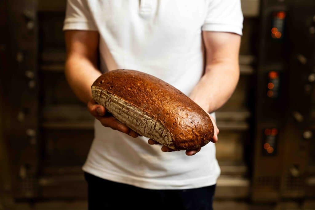 Ein Mitarbeiter hält ein Leib Brot.